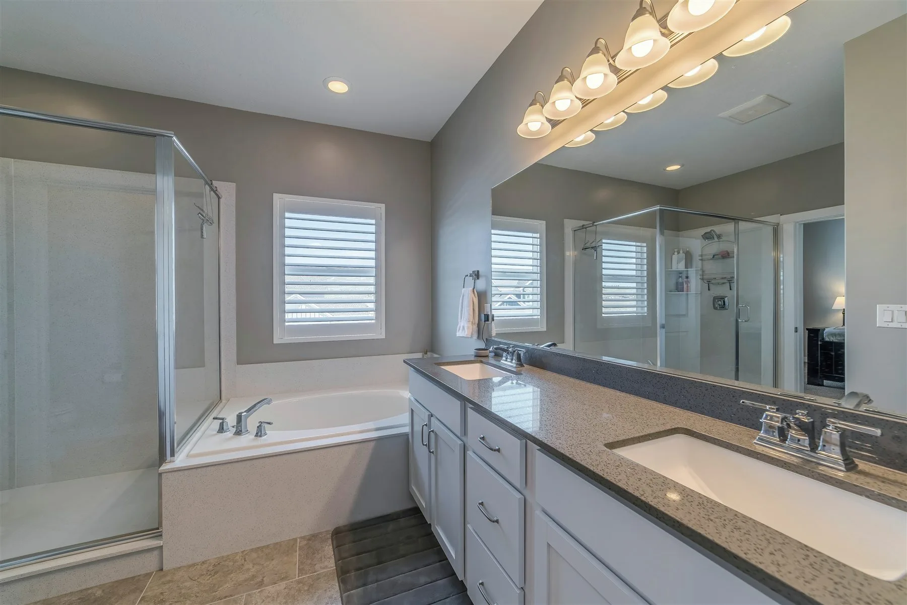 Finished double vanity with layered mirror and ceiling lighting