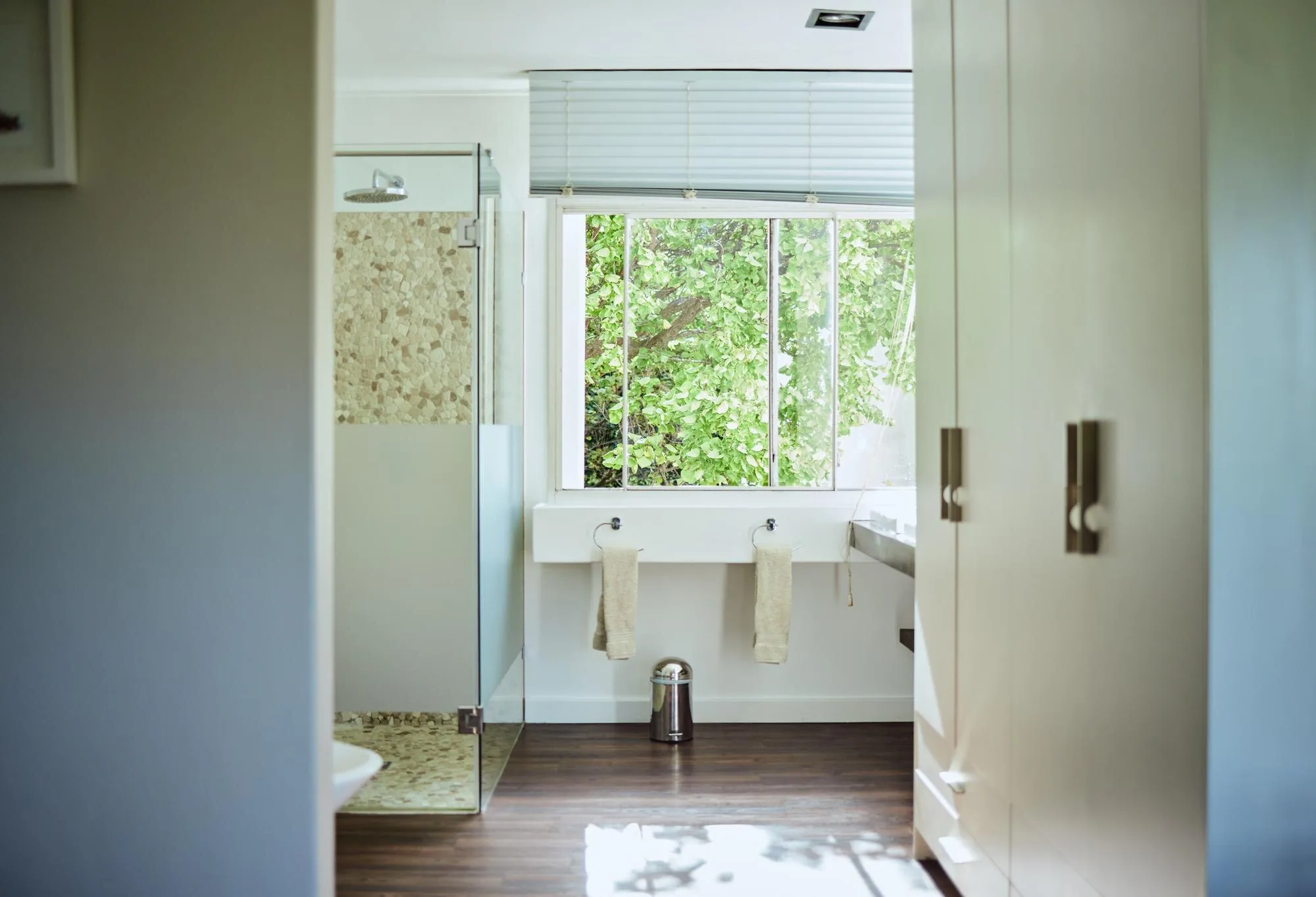 Naturally lit residential bathroom with a shower and vanity